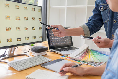 Midsection of woman using laptop on table