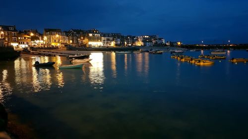 Illuminated cityscape against sky at night