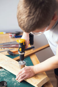 Home workshop. close-up of a man in goggles working with a drill.