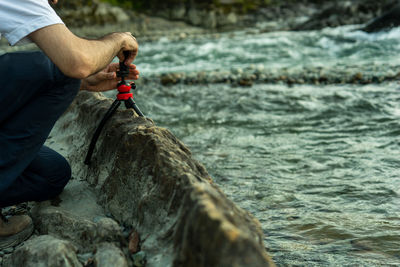 Low section of man photographing on rock