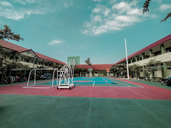 View of playground by buildings against sky