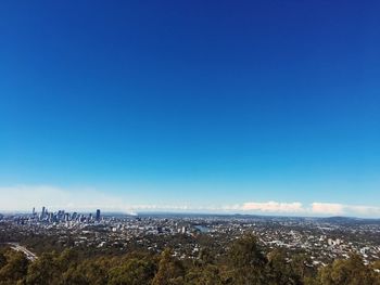 Aerial view of city against blue sky