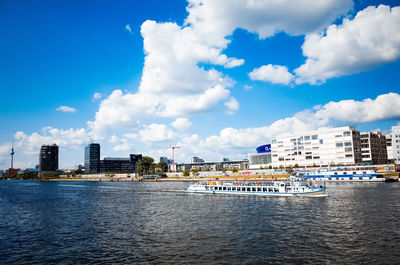 Distant view of fernsehturm by river and buildings in berlin