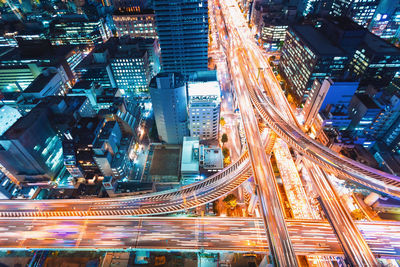 High angle view of illuminated city street and buildings at night