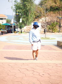 Rear view of woman walking on footpath in city