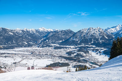 Scenic view of snowcapped mountains against blue sky