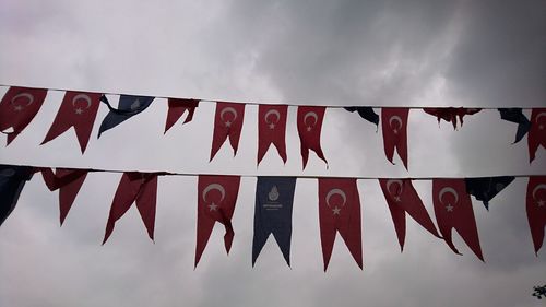 Low angle view of flags hanging against sky