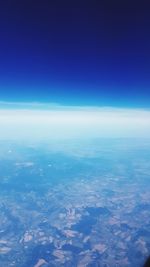 Aerial view of sea and landscape against blue sky