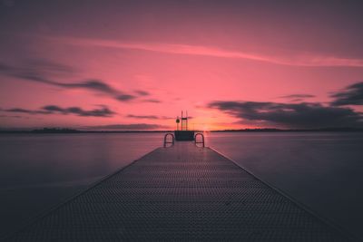 Jetty on sea against sky during sunset