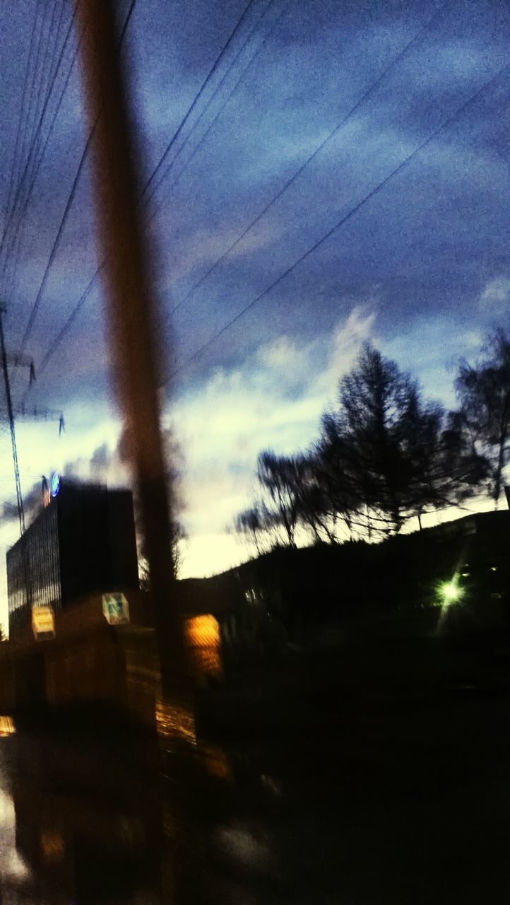 silhouette, sky, sunset, power line, tree, building exterior, built structure, architecture, dusk, electricity pylon, low angle view, cloud - sky, electricity, street light, cable, street, illuminated, transportation, dark, cloud