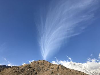 Low angle view of mountain against blue sky