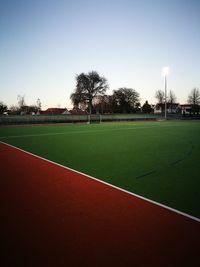 Scenic view of soccer field against clear sky