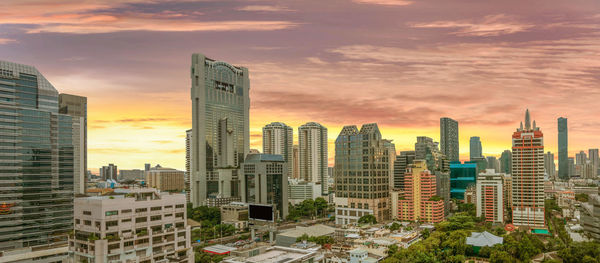 Skyscrapers in city against cloudy sky