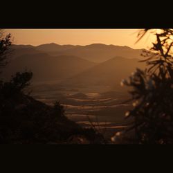 Scenic view of silhouette mountains against sky at sunset