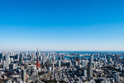 Aerial view of city buildings against blue sky