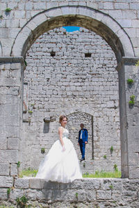 Rear view of woman standing against historic building