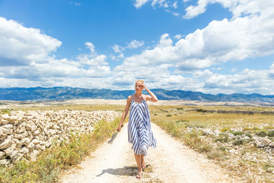 Woman standing on landscape against sky