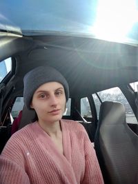 Portrait of young woman sitting in car