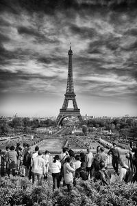 Tourists looking at eiffel tower against sky