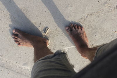 Low section of man legs on sand