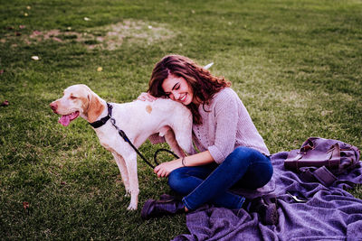 Woman with dog sitting on grass