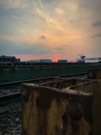 Train in city against sky during sunset