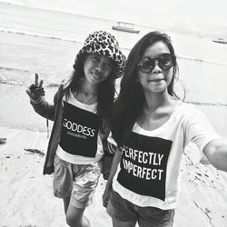 Portrait of smiling young woman standing on beach