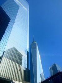 Low angle view of skyscrapers against blue sky