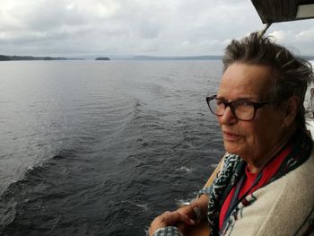 Portrait of man wearing sunglasses at sea against sky