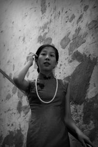 Portrait of woman standing against wall