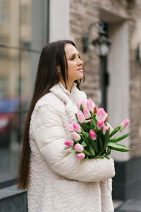 Portrait of young woman holding bouquet