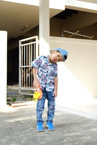 Full length of happy boy playing with umbrella