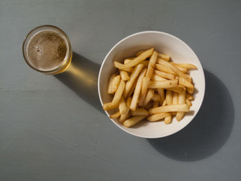 Directly above shot of beer and french fries on table