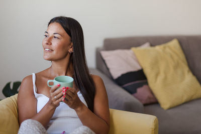 Young woman sitting on sofa