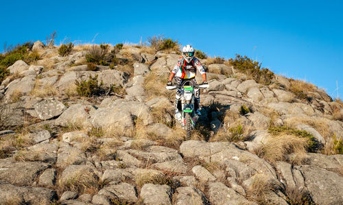 People riding motorcycle on rock