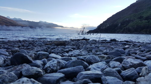 Surface level of pebble beach against the sky