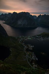 Scenic view of lake by mountains against sky during sunset