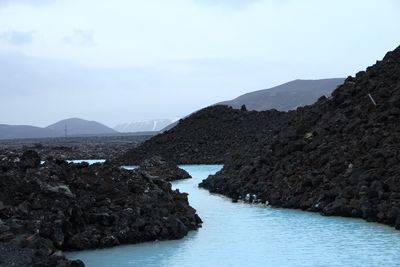 Scenic view of sea and mountains against sky