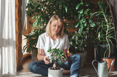 Woman potting plant at home