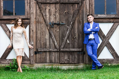 Portrait of couple standing against door