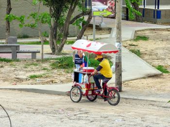 People riding bicycle on street in city