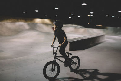 Boy riding bicycle at skateboard park