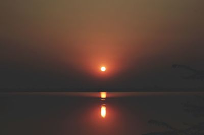 Scenic view of lake against orange sky during sunset