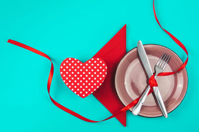 High angle view of red heart shape on blue table