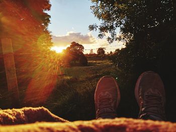 Low section of person against sky during sunset