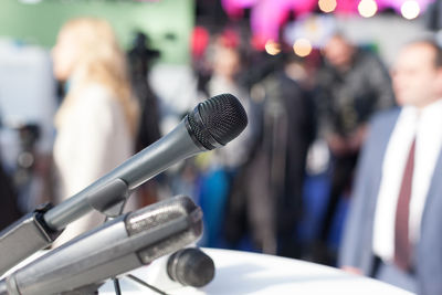 Close-up of microphone with people in background