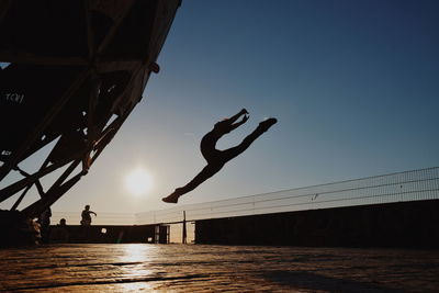 Silhouette ballet dancer dancing against sky during sunset