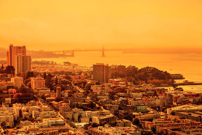 High angle view of buildings in city during sunset