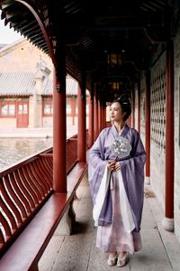 Portrait of young woman standing in city