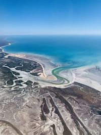 High angle view of sea against clear blue sky